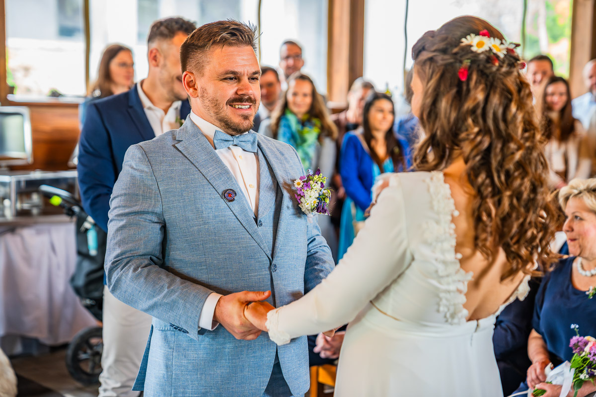 Ženich drží nevěstu za ruce při obřadu