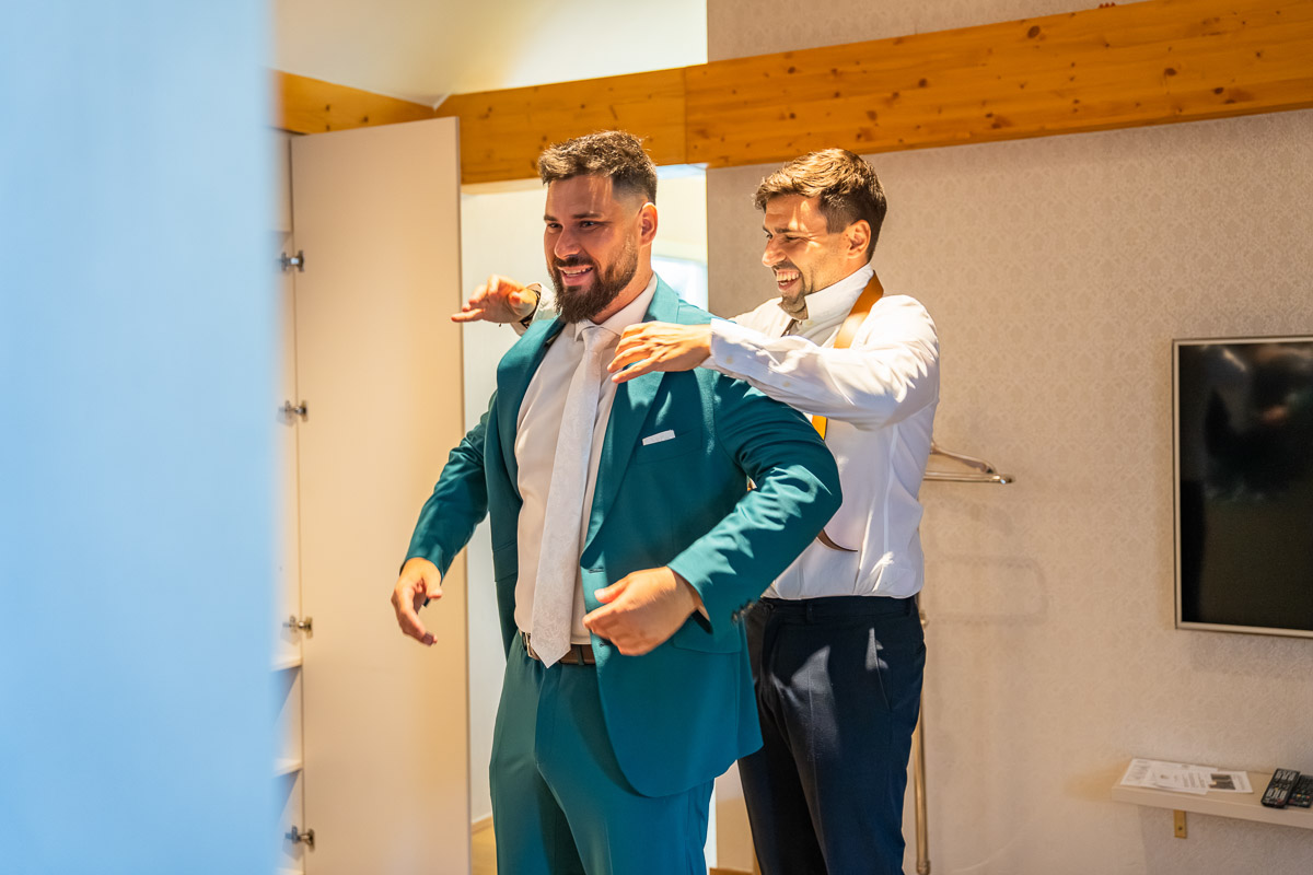 Svědek pomáhá ženichovi do saka