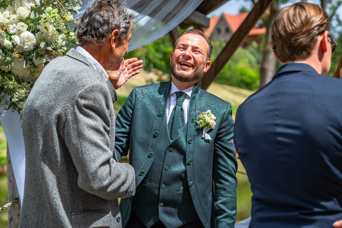 Smějící se ženich přijímá gratulace