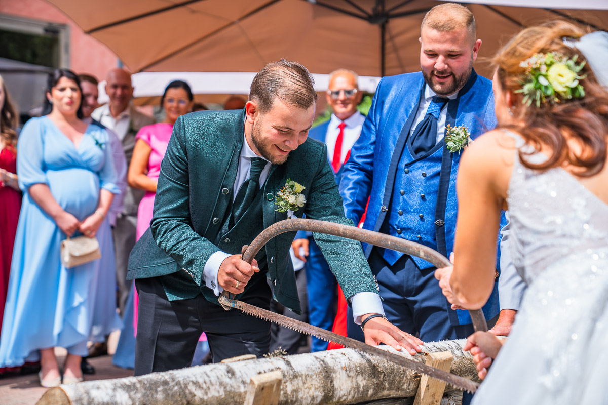Novomanželé společně řežou kládu